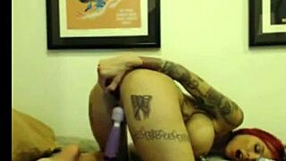Tattooed cam girl teases with dildo in pussy and ass.
