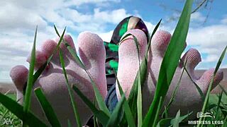 Adoring her cute feet in white socks on spring grass with jeans.