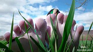 Adoring her cute feet in white socks on spring grass with jeans.