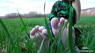 Adoring her cute feet in white socks on spring grass with jeans.