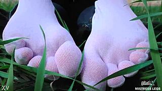 Adoring her cute feet in white socks on spring grass with jeans.