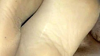 Footjob with a girl in black sheer nylons, captured in a homemade setting