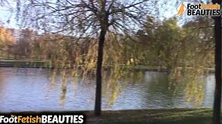 A brunette woman removes her socks and walks barefoot in the public park