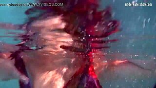 Redhead babe Nikita Vodorezova strips naked quickly in underwater pool scene