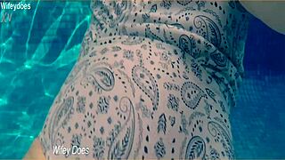 Wife swims leisurely in hotel pool wearing sleek one-piece swimsuit preview